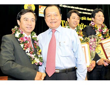 Le Thanh Hai (R), secretary of the HCMC Party Committee, congratulating a Ton Duc Thang Award winner on August 18 (Photo: SGGP)